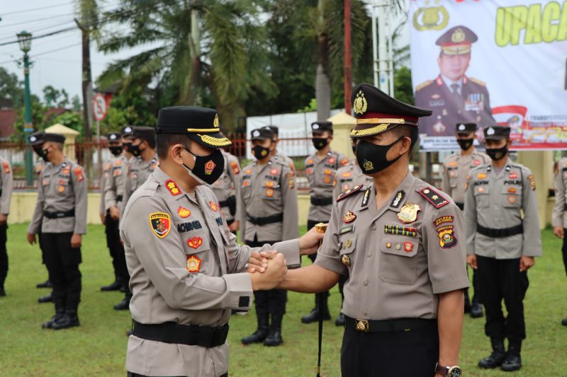 Kapolres Musi Rawas AKBP Ahmad Gusti Hartono saat memberikan ucapan selamat kepada Kapolsek Purwodadi Kompol Madriji usai upacara kenaikan pangkat pengabdian di halaman Mapolres Mura, Rabu (2/2)