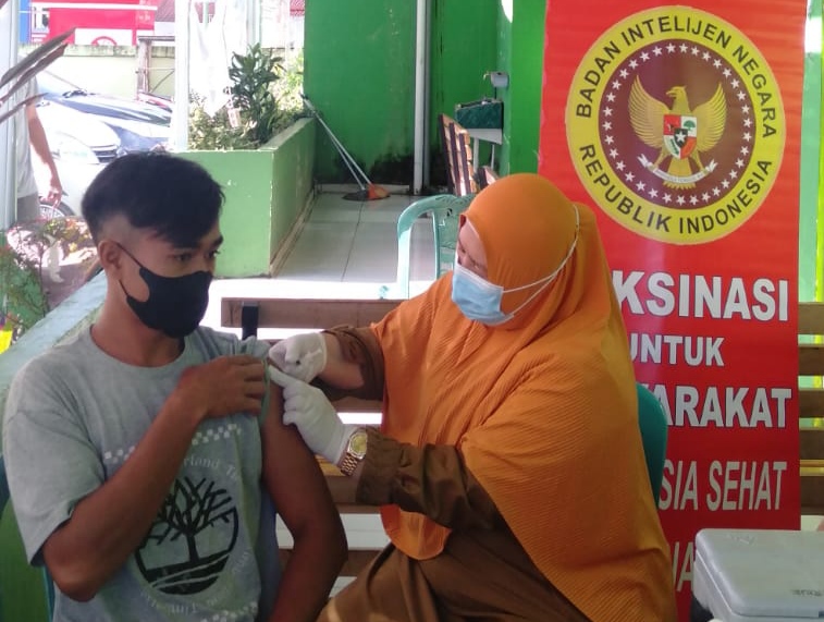 Tenaga kesehatan Puskesmas memberikan pelayanan suntik vaksin kepada masyarakat
