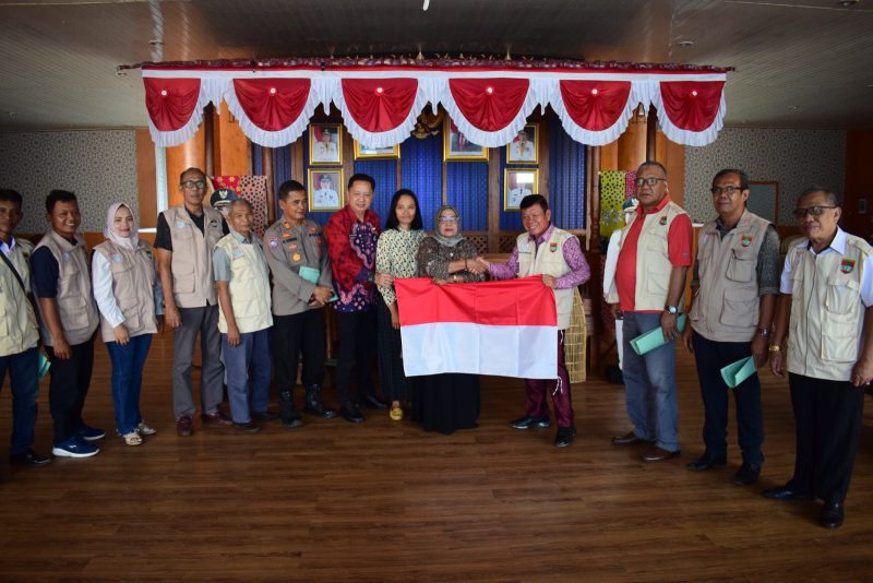 SERAHKAN-Wakil Bupati Mura Hj Suwarti saat menyerahkan bendera merah putih kepada Ketua FPK Mura H Thamrin Hasan usai rapat bersama pengurus dan anggota FPK Mura, Kamis (13/7). 