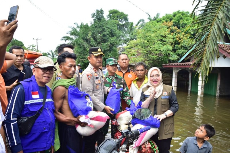 Bupati Musi Rawas Hj Ratna Machmud didampingi Wakapolres Mura Kompol Harsono saat menyalurkan bantuan kepada korban banjir di Desa Sembatu Jaya, Kecamatan BTS Ulu. 