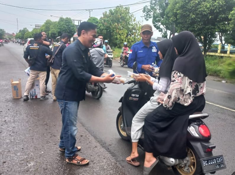 Ketua PWI Mura Jhuan Silitonga bersaman PR KKKS SRMD Tan Hari saat membagikan takjil di Simpang F Trikoyo, Kecamatan Tugumulyo, Kabupaten  Musi Rawas.