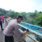 Anggota Polres Musi Rawas melakukan kegiatan ngecat Jembatan Merah Putih Sungai Kungku di Desa Purwodadi, Kecamatan Jayaloka, Kabupaten Musi Rawas